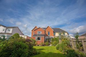 a large brick house in a yard with a fence at The Annexe at Clarendon in Bovey Tracey