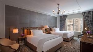 a hotel room with two beds and a chandelier at InterContinental New York Barclay Hotel by IHG in New York +101 photos