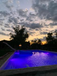 a swimming pool with purple lighting at sunset at El Mirador in Buenache de la Sierra