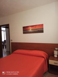 a bedroom with a red bed and a painting on the wall at Monviso in SantʼAlbano Stura