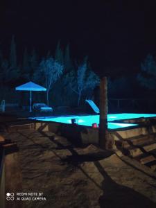 una piscina por la noche con luces azules en El Mirador, en Buenache de la Sierra