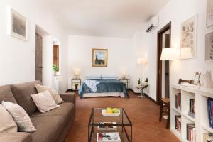 a living room with a couch and a bed at In Toscana Camere in Monticchiello