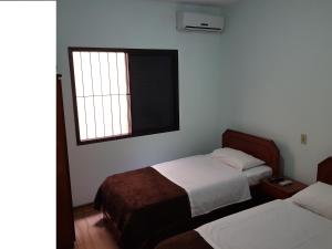 a bedroom with two beds and a window at Hotel Valle Sul in Registro