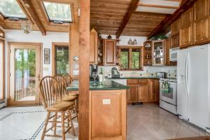 a kitchen with wooden cabinets and a white refrigerator at Lake Winni - WF - 383 in Moultonborough