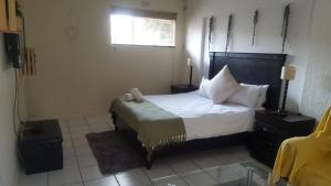 a bedroom with a bed with white sheets and pillows at Self-catering 1Bedr cottage in Sandton with FREE WiFi in Johannesburg