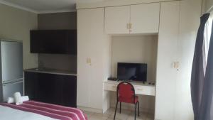 a bedroom with a bed and a desk and a red chair at Self-catering 1Bedr cottage in Sandton with FREE WiFi in Johannesburg