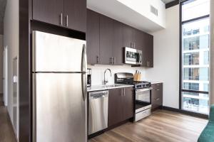 a kitchen with a refrigerator, stove, sink and cabinets at Sonder South Wabash in Chicago