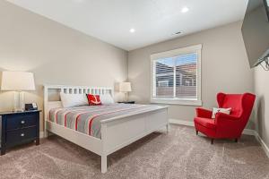 a bedroom with a bed and a red chair at Lochwood Getaway in Garden City