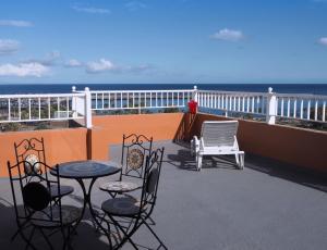 een balkon met een tafel en stoelen en de oceaan bij apartamentos la villa 2 in San Sebastián de la Gomera