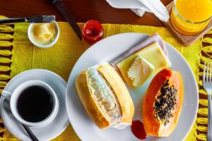 a plate with two sandwiches and a cup of coffee at Pousada e Restaurante Mangue Seco Angra in Angra dos Reis