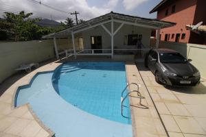 a car parked next to a house with a swimming pool at Suite em Casa Juquehy 2 in Juquei