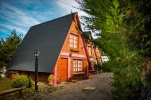 a large wooden house with a black roof at Patagonia Encantada in Esquel