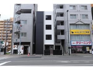een lege straat met twee hoge gebouwen bij Uchi Living Stay AOZORA in Sapporo