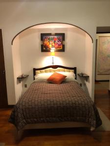 a bedroom with a large bed with an arched headboard at "LA MAISON DE LA BOLIVIE" Casa de Huéspedes in La Paz