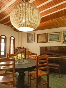 a dining room with a table and a piano at Pousada Porto Praia in Arraial do Cabo