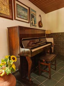 an old piano in a room with a vase of flowers at Pousada Porto Praia in Arraial do Cabo