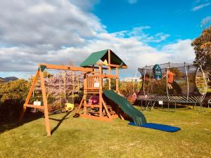 a playground with a slide and a swing set at Cascades Lakefront Motel in Taupo