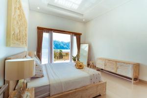 a bedroom with a bed with a teddy bear sitting on it at Villa Jempana Kintamani in Kintamani