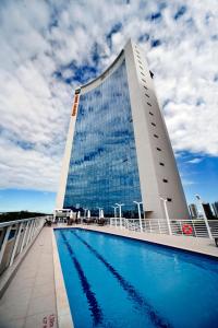 a building with a swimming pool in front of a building at Quality Hotel Vitória in Vitória