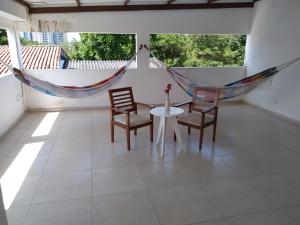 Habitación con mesa, sillas y hamaca. en Acupe de Brotas, en Salvador