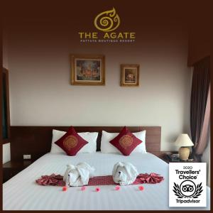 A bed or beds in a room at The Agate Pattaya Boutique Resort