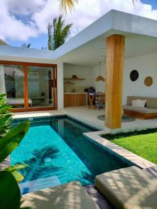 a villa with a swimming pool and a house at Kalea Villas in Kuta Lombok