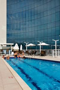 eine Gruppe von Personen in einem Schwimmbad vor einem Gebäude in der Unterkunft Quality Hotel Vitória in Vitória