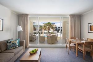 a living room with a couch and a table at Mantra Ettalong Beach in Ettalong Beach