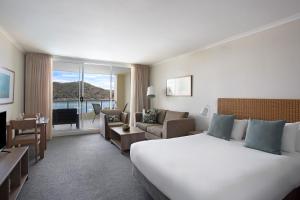 a hotel room with a large bed and a large window at Mantra Ettalong Beach in Ettalong Beach