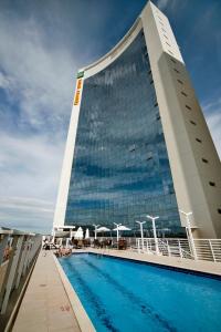 a building with a swimming pool in front of it at Quality Hotel Vitória in Vitória