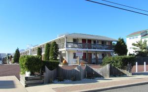 une maison blanche avec une clôture devant elle dans l'établissement Sea Spray Motel, à Beach Haven
