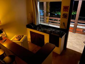 a small kitchen with a stove and a window at Pousada Morrison in Praia do Rosa