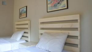 a bedroom with two beds with white pillows at RedDoorz At Home 33 Bandung in Bandung