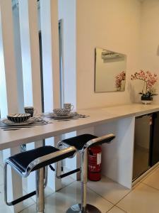 a table with two bar stools in a room at Ellkay Studio Suite at Evo Bangi in Kampong Sungai Ramal Dalam