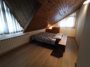 a bedroom with a bed in a room with windows at A casa da Balbina in Betanzos