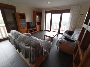 a living room with a couch and a television at A casa da Balbina in Betanzos