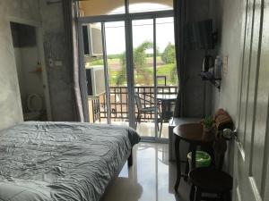 素叻的住宿－You In House URT Surathani Airport，一间卧室设有一张床,享有阳台的景色