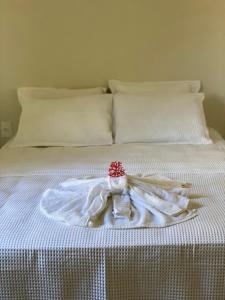 ein weißes Bett mit einem Teller mit einer Serviette und einer Kerze in der Unterkunft Casa Rasa in Búzios + 12 Fotos