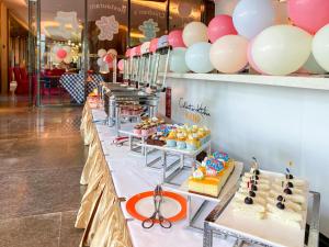a buffet line with cakes and pastries and balloons at Sanya Conifer Resort in Sanya