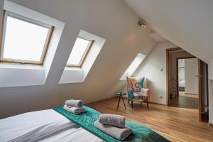 sypialnia na poddaszu z łóżkiem i 2 oknami w obiekcie LUXURIOUS APARTMENTS Cracow w Krakowie