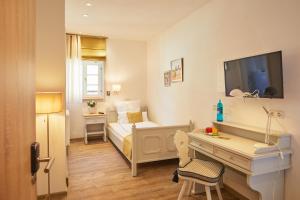 1 dormitorio con 1 cama y escritorio con TV en Hotel Landgraf en Schwalmstadt