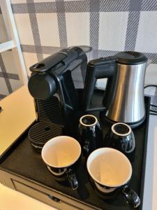 a coffee maker sitting on a counter with two cups at Amsterdam Hotel Uithoorn in Uithoorn