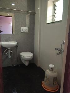 a bathroom with a toilet and a sink at Aakash Residency in Madurai