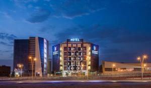 a hotel with two tall buildings at night at Art View Hotel Al Riyadh in Riyadh
