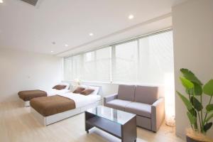 - un salon avec un lit et un canapé dans l'établissement Cozy and Convenient Royal heights, à Sapporo