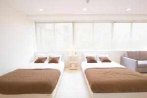- 2 lits dans une chambre blanche avec fenêtres dans l'établissement Cozy and Convenient Royal heights, à Sapporo