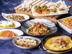 uma mesa coberta com pratos de comida e tigelas de comida em Hotel Wing International Hida Takayama em Takayama