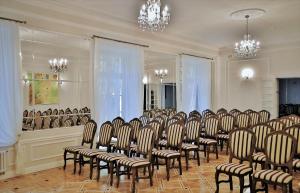 a room with rows of chairs and chandeliers at Pałac Kobylin in Kobylin