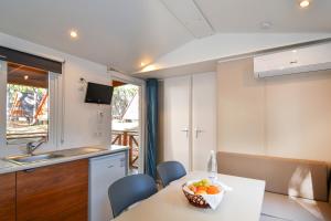 a kitchen with a table with a bowl of fruit on it at Spina Family Camping Village in Lido di Spina