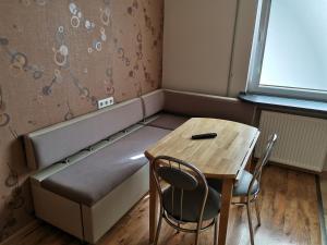 ケダイネイにあるSunny apartment Kėdainiaiのベッド、テーブル、椅子が備わる小さな客室です。